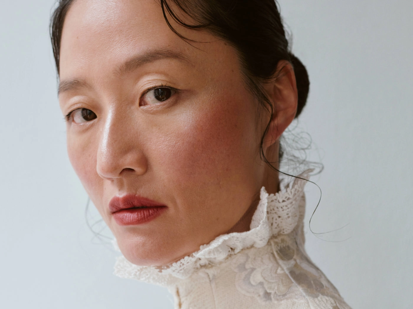 Portrait of a woman with a soft red lip and a lace collar