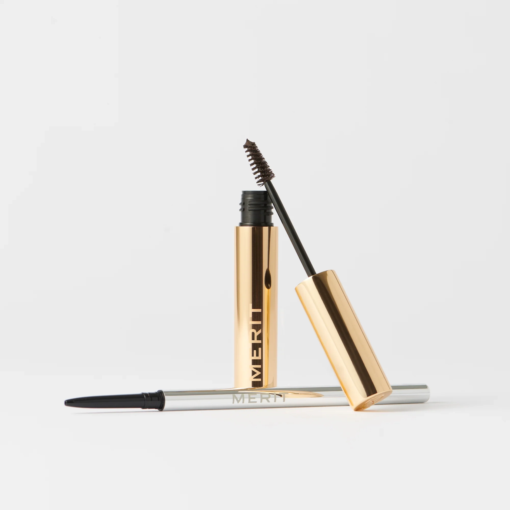 Brow 1990 and Brow 1980 stood next to a mascara and a brow pencil