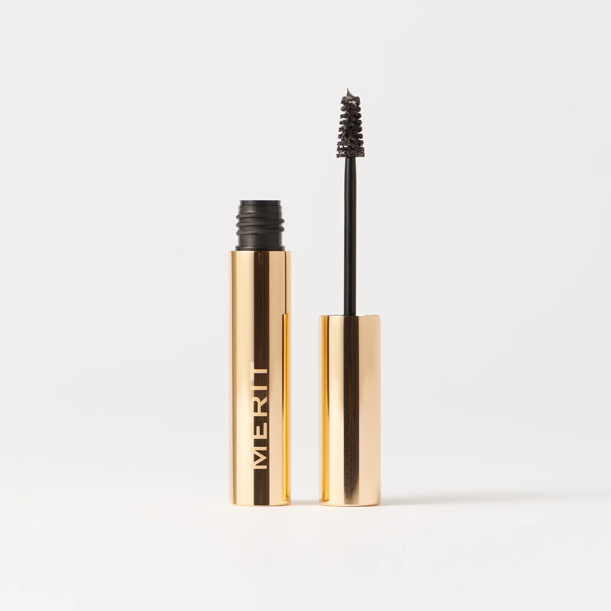 Brow pomade with gold packaging on a white background